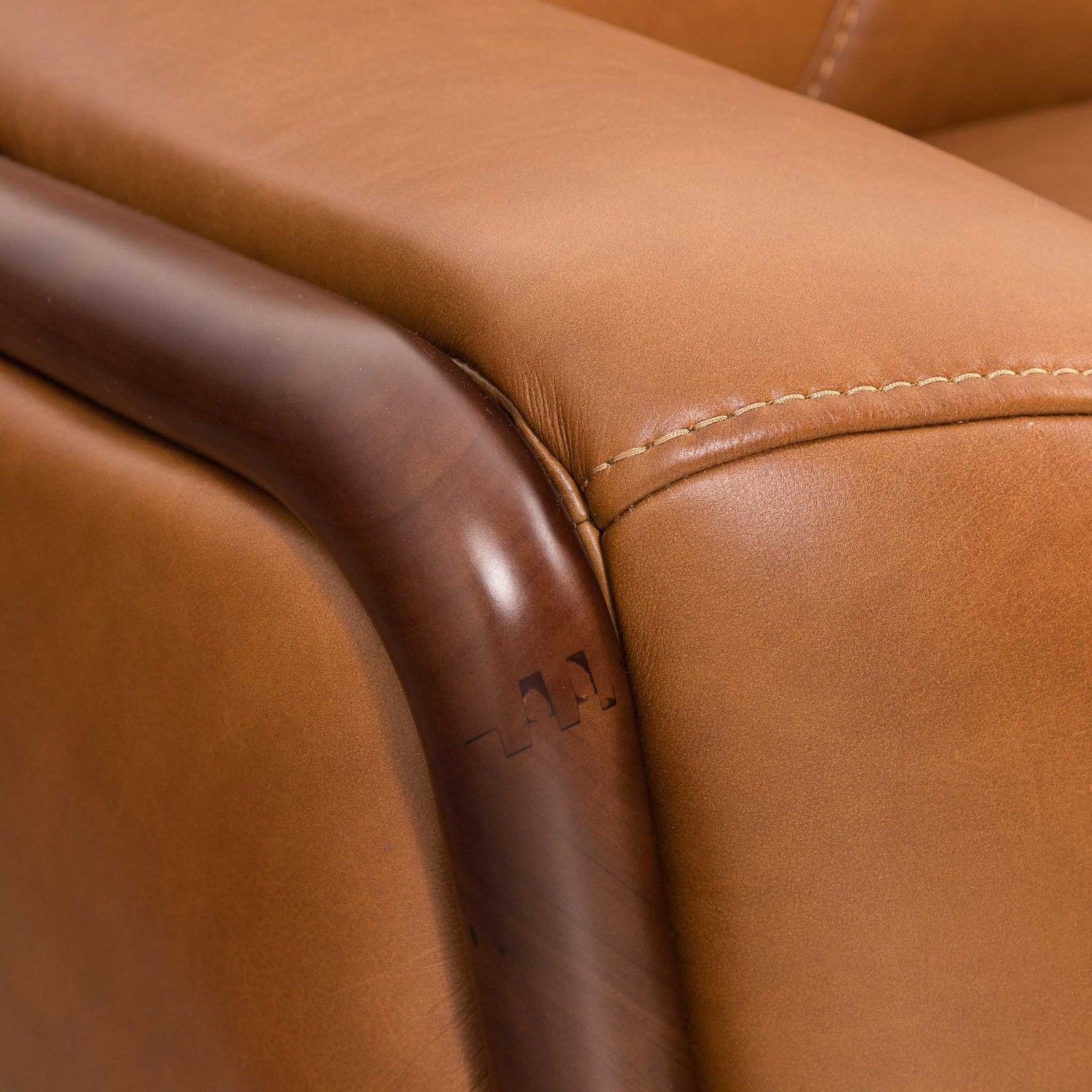Close-up of the Leather Gallery Zuri 1 Seater Leather Couch in Czar Pecan, showing dark wooden armrests and visible stitching.
