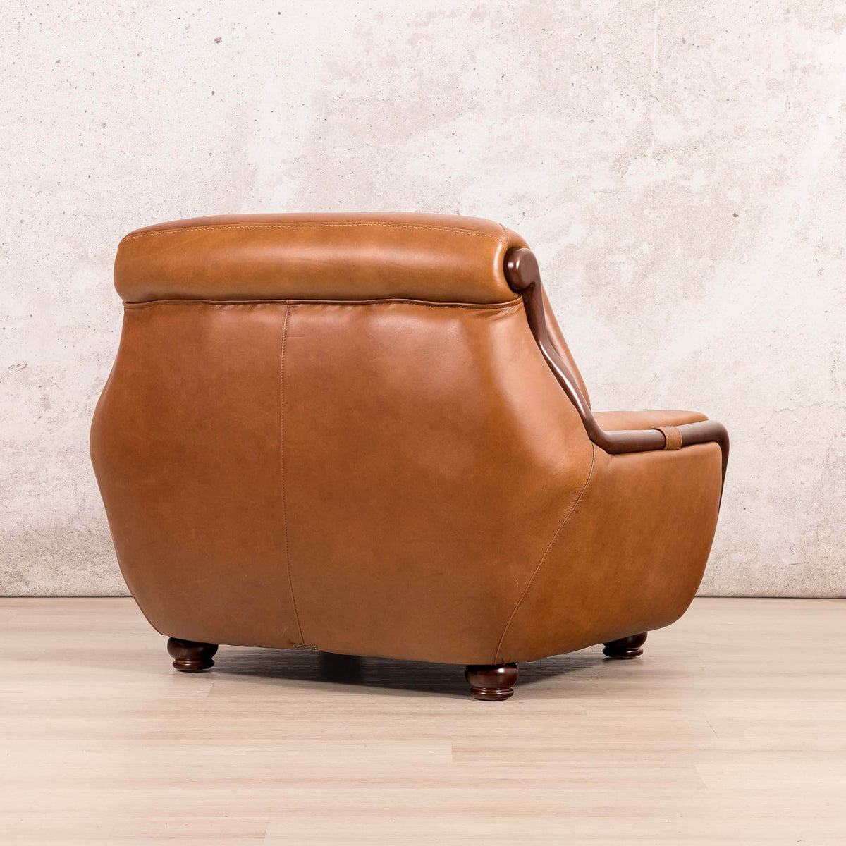 Three-quarter view of the Leather Gallery Zuri 1 Seater Leather Couch in Czar Pecan, featuring dark wooden legs and warm leather upholstery.