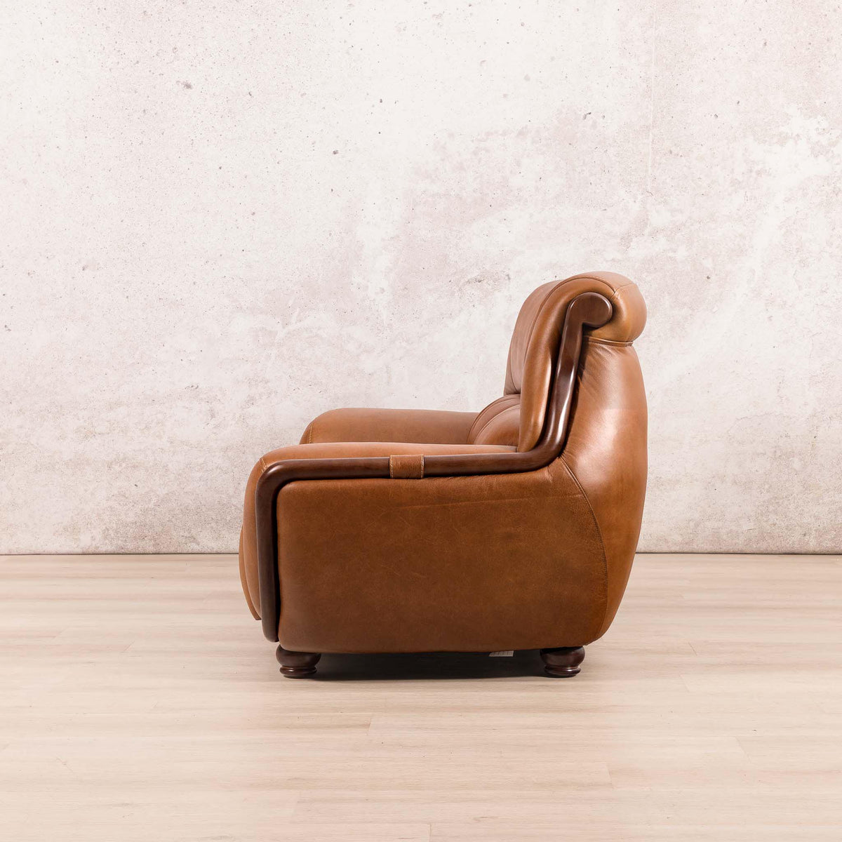Side view of the Leather Gallery Zuri 2 Seater Leather Couch in Czar Pecan, featuring rolled arms and dark wooden legs.