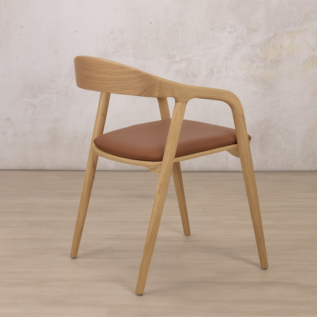 Rear view of the Alaric leather dining chair highlighting the seamless grain of the ash wood backrest. modern dining chairs, leather dining chair, carver dining chair