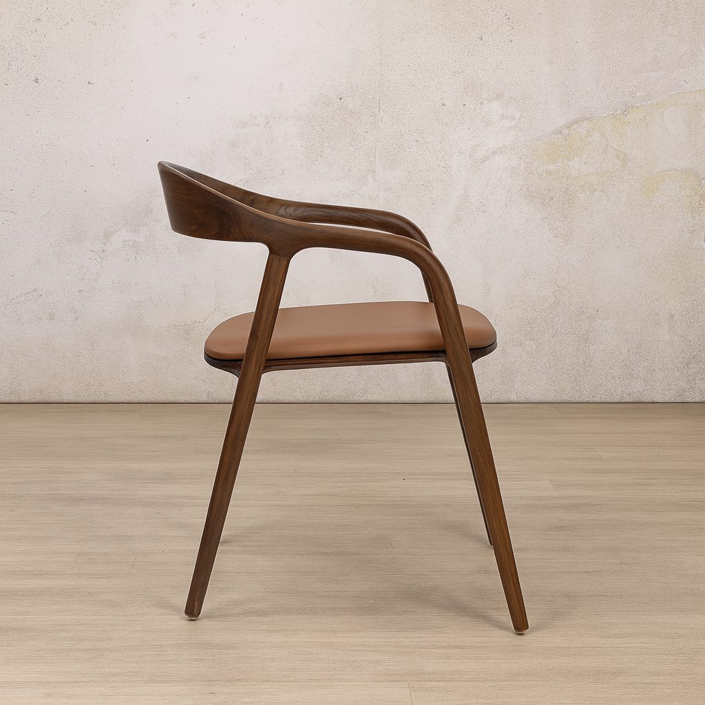 Side view of an Alaric Leather Dining Chair, a sturdy wooden dining chair in a warm walnut finish. 