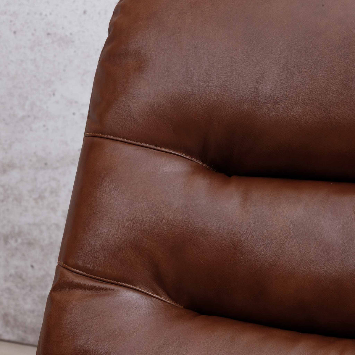 Close-up of the Leather Gallery Dallas Leather Rocker Recliner Chair in Saddle, showing the leather armrest and visible stitching detail.