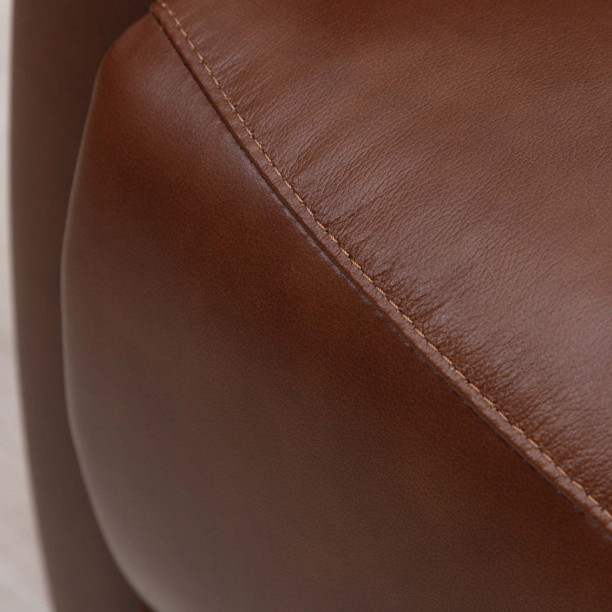 Close-up of the Leather Gallery Dallas Leather Rocker Recliner Chair in Saddle, showing the leather grain and curved seam detail.
