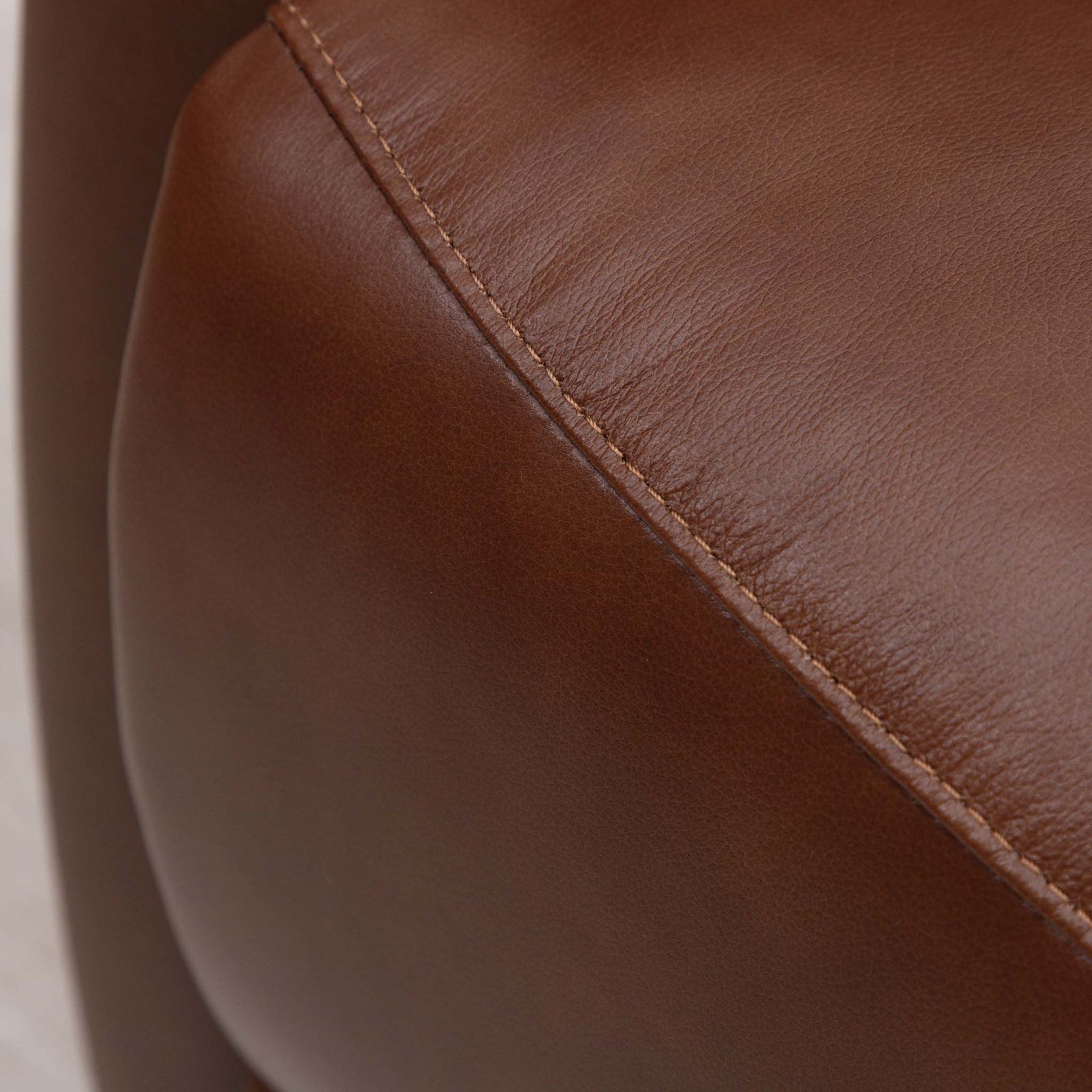 Close-up of the Leather Gallery Dallas Leather Rocker Recliner Chair in Saddle, showing the leather grain and curved seam detail.