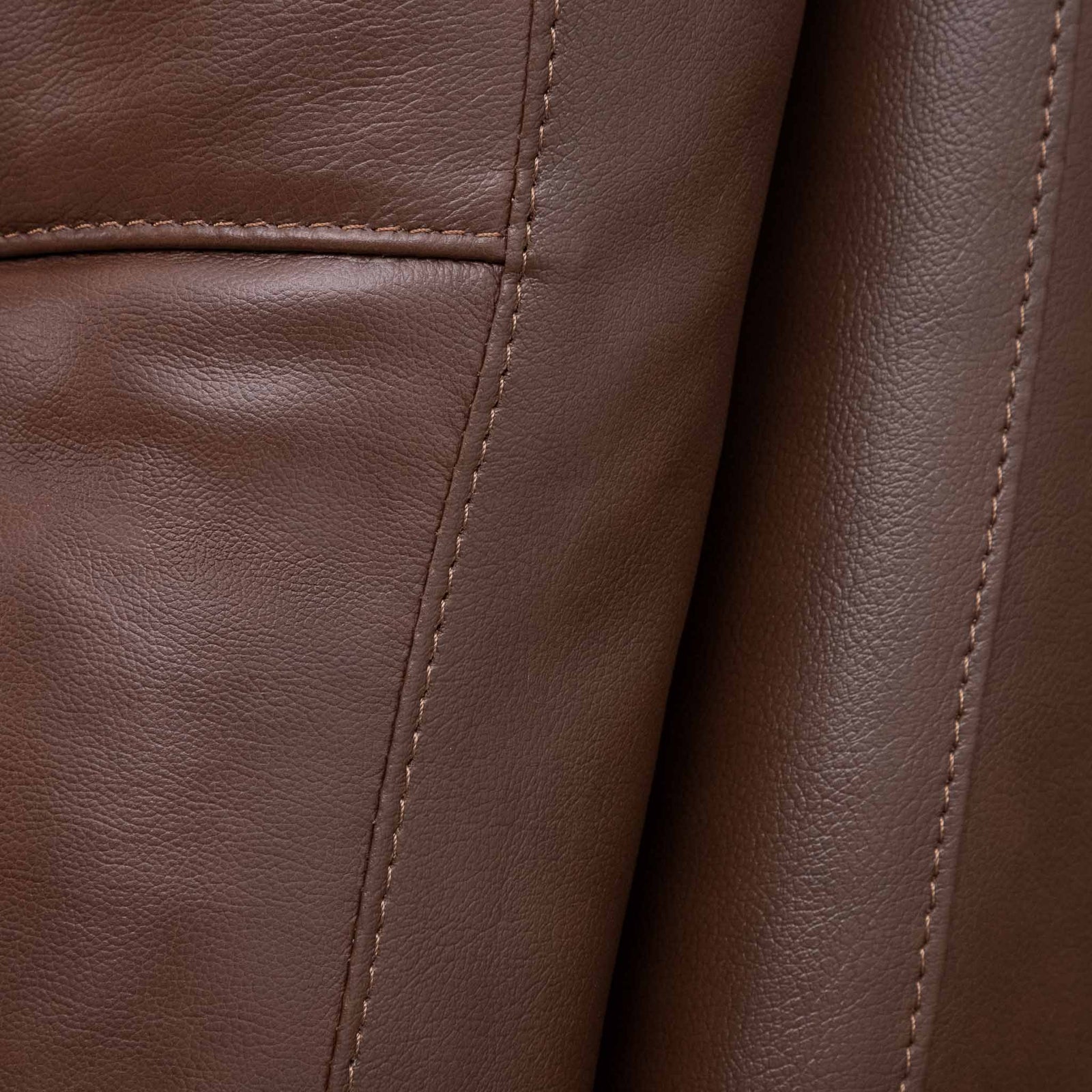 Close-up of the Leather Gallery Dallas Leather Rocker Recliner Chair in Saddle, showing the leather grain and stitched panel seams.