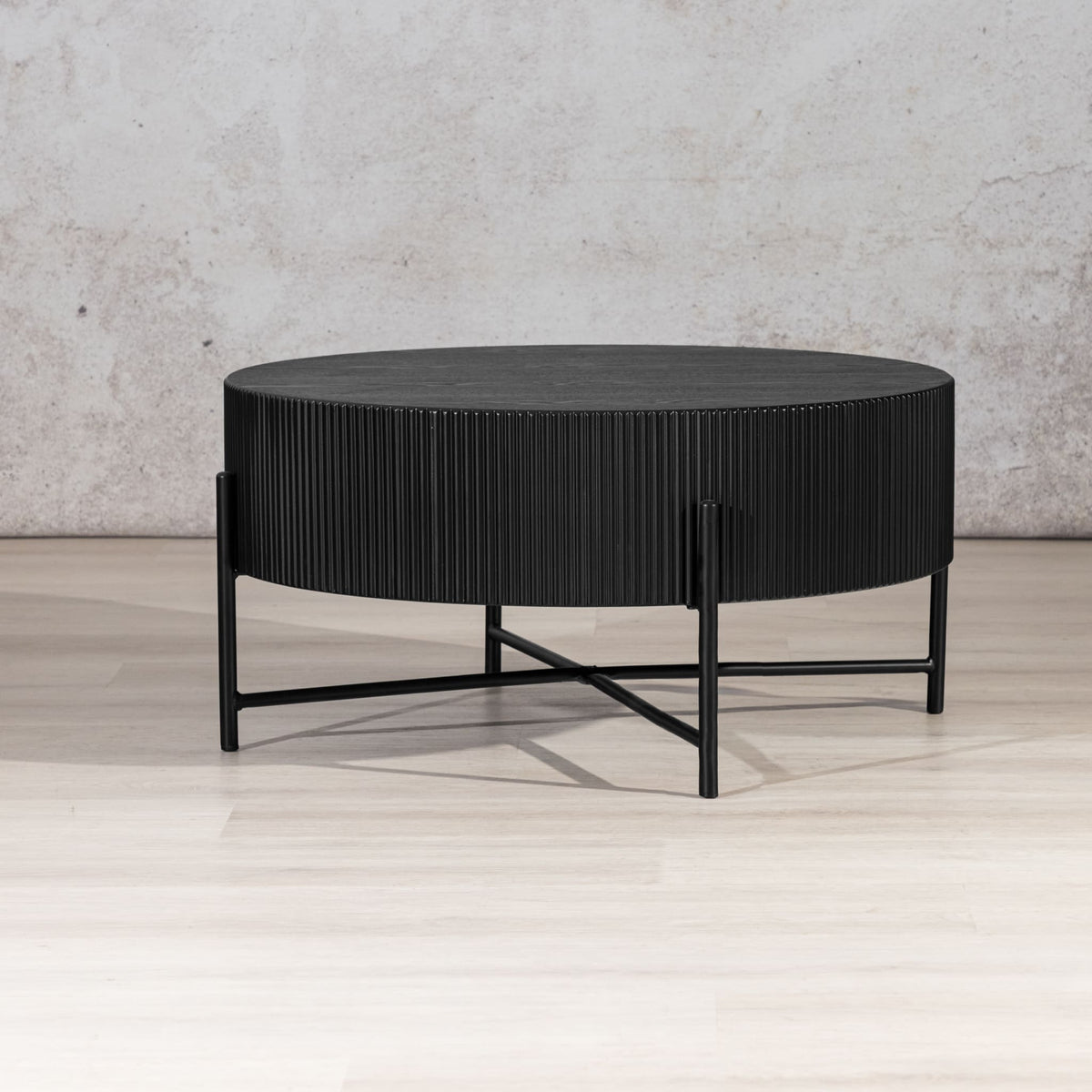 Armstrong Coffee Table, a black drum-style coffee table with slender metal X-frame legs. modern coffee table, wood coffee table