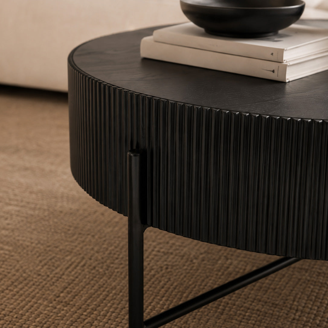 Close up view of the Armstrong black coffee table styled with books and vase, showing drum-style tabletop. | Coffee Tables, black coffee table, wood coffee table