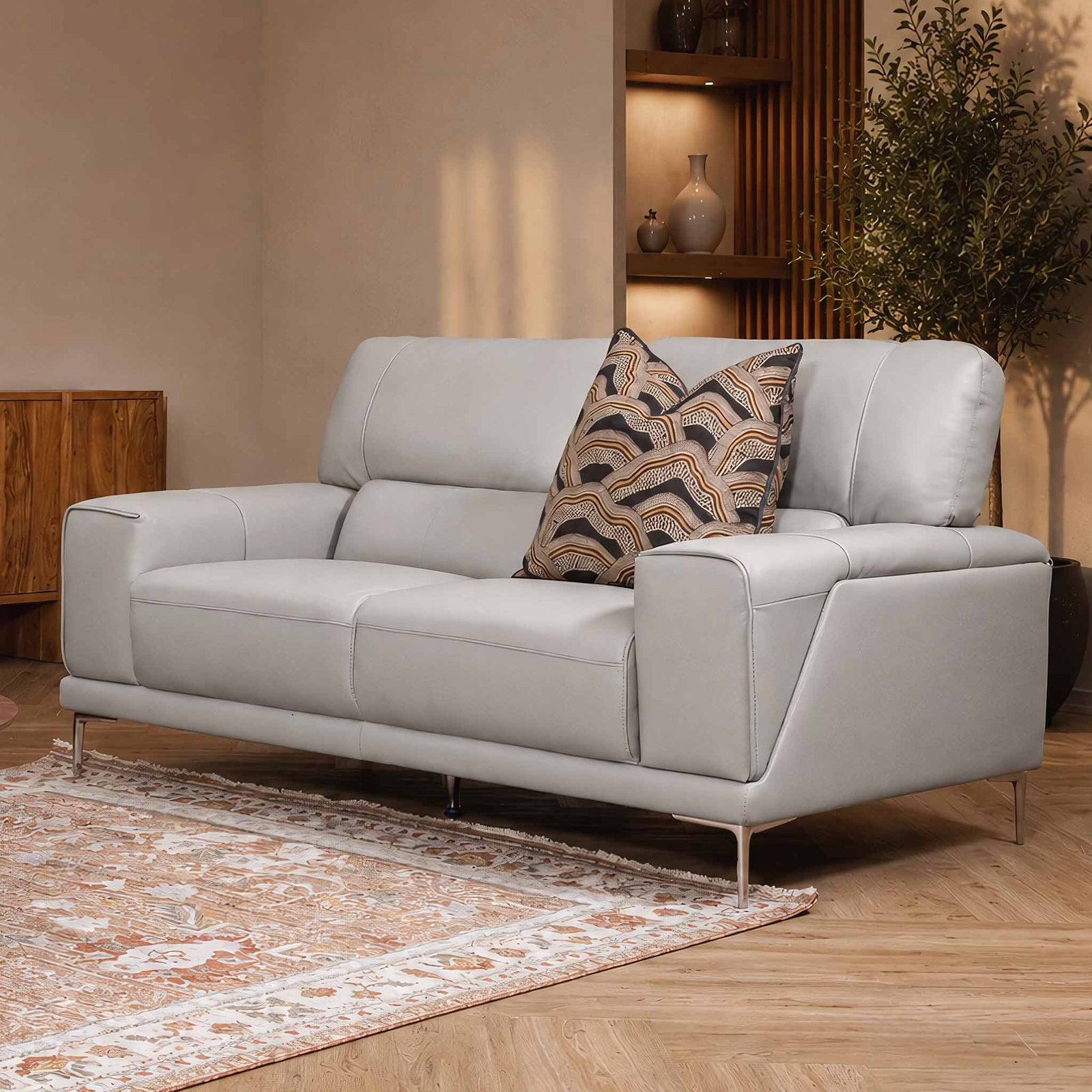 Leather Gallery Atlanta 2 Seater Leather Couch in Luxe Beige, styled with slim metal legs, a patterned cushion, and warm living room décor.