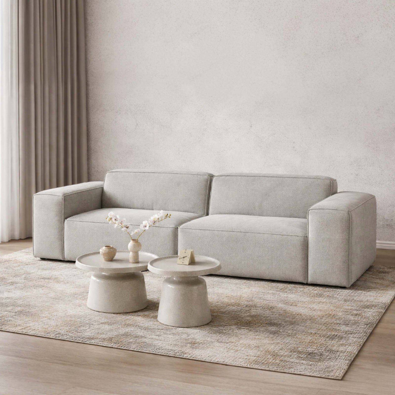 Austin Fabric 3-seater couch in Bordeaux Grey, styled in a minimalist living area, complemented by stylish white coffee tables. | Fabric Couches, 3 seater couch, luxury couch, grey couch