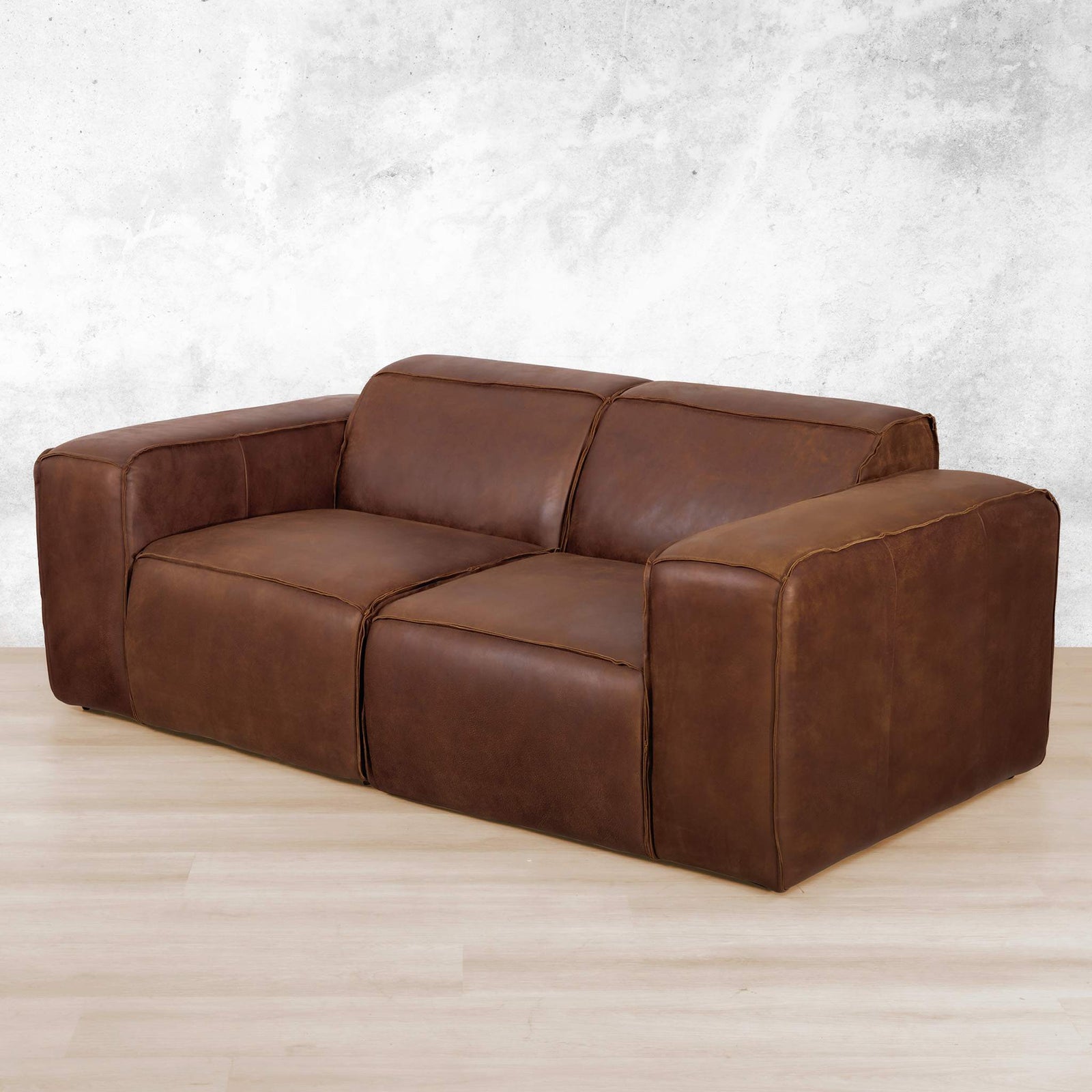 Austin 2 Seater Leather Couch  in Woodlands Spice, in a bright, modern-minimalist styled living room. Genuine leather couches. Woodlands Spice