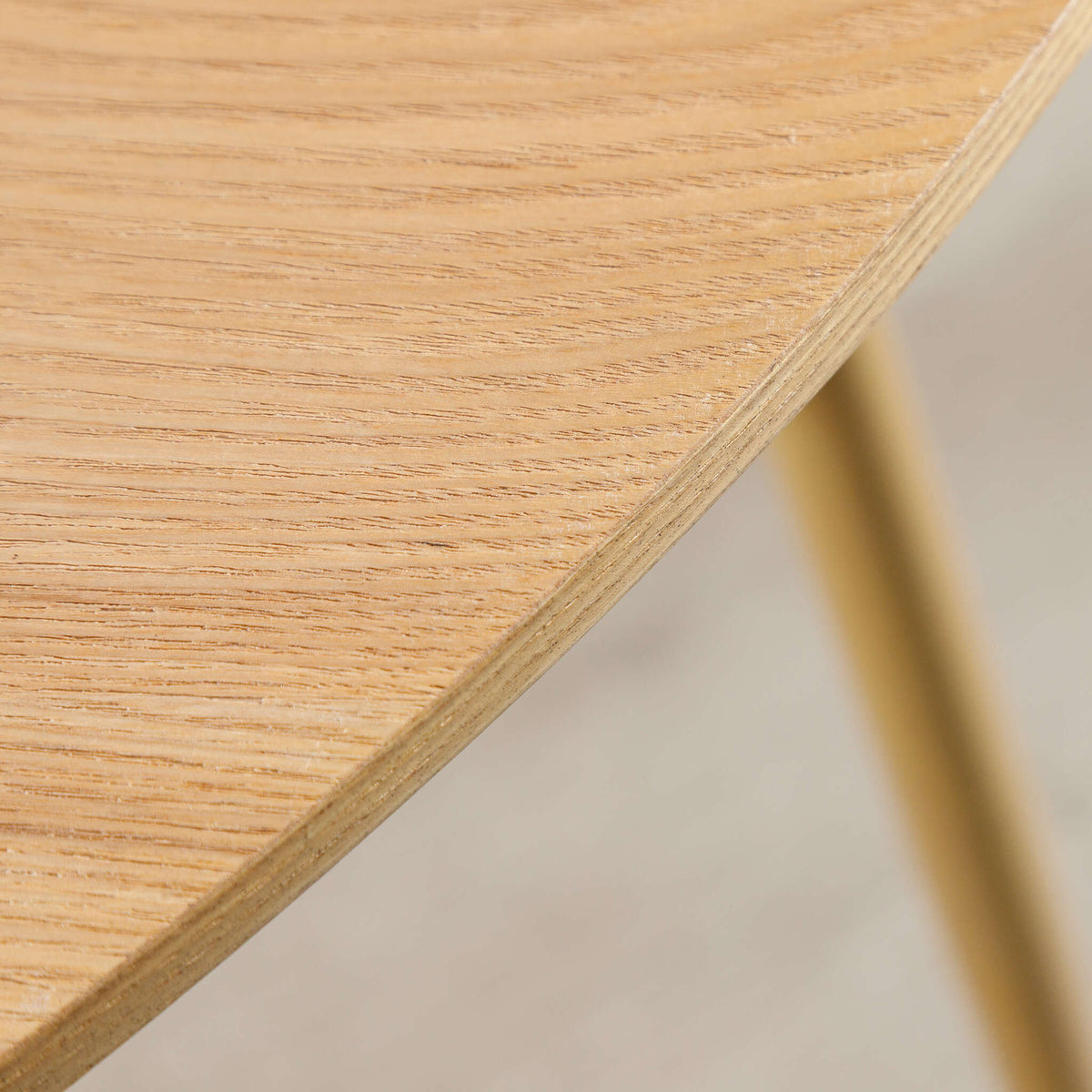 Close-up of Beckett dining table's tabletop edge and tapered wood leg. 