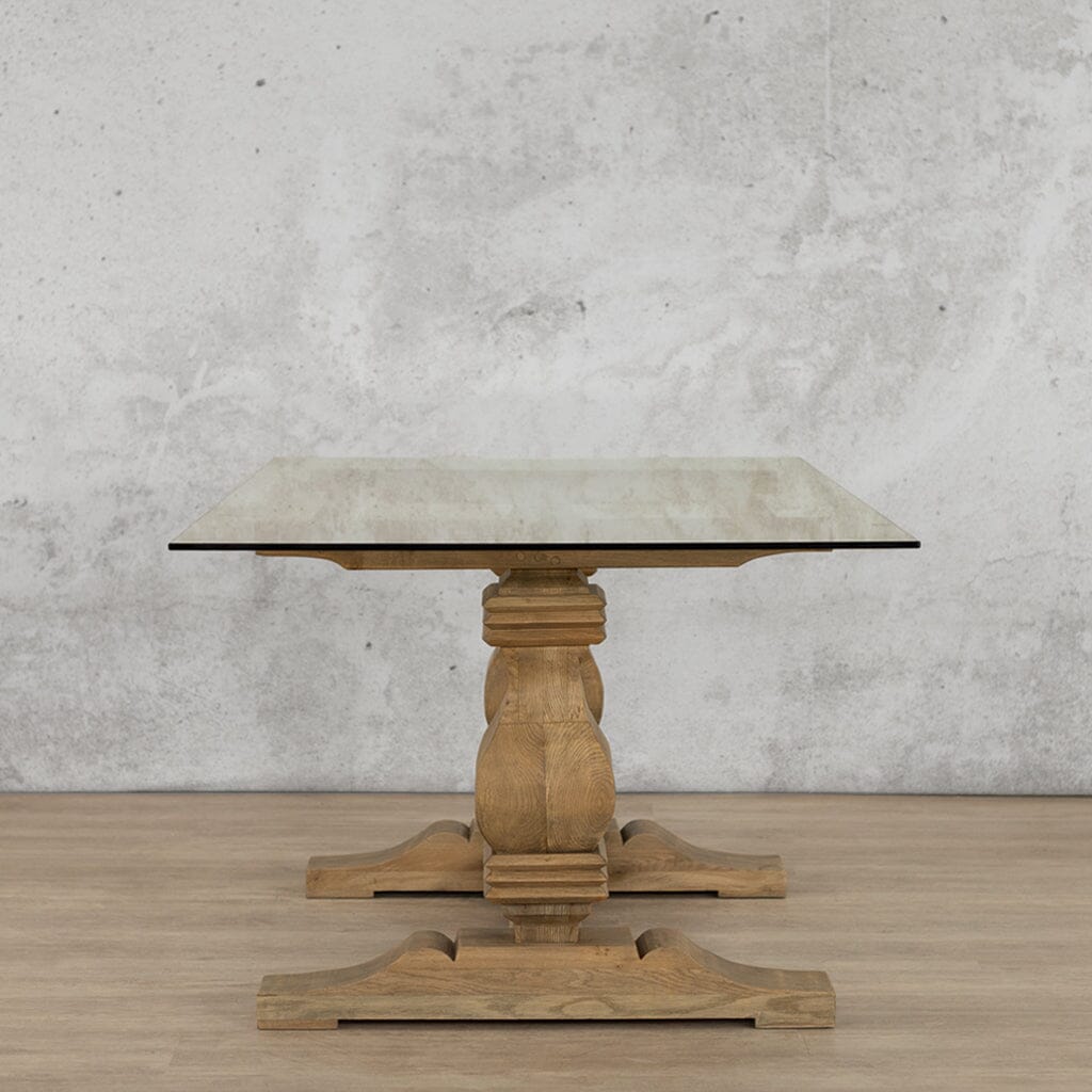 Side view of the Belmont Glass Top Dining Table – 2.4m / 8-10 Seater in Antique Natural Oak, highlighting its elegant proportions and solid wood base that complements the chic glass top. Leather Gallery -antique-natural-oak