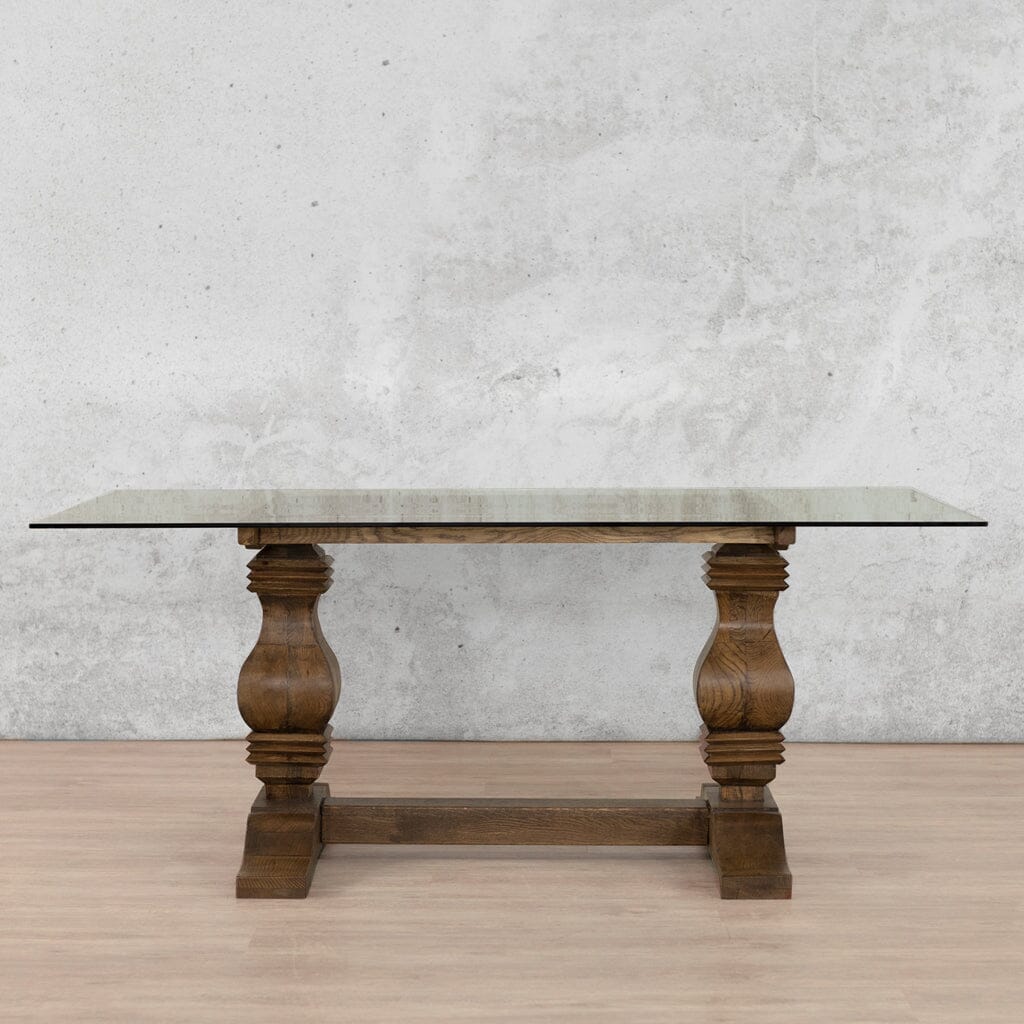 Front view of the Belmont Glass Top Dining Table – 2.4m / 8-10 Seater, featuring a rich Antique Dark Oak base paired with a pristine glass top for a luxurious dining setting. Leather Gallery 