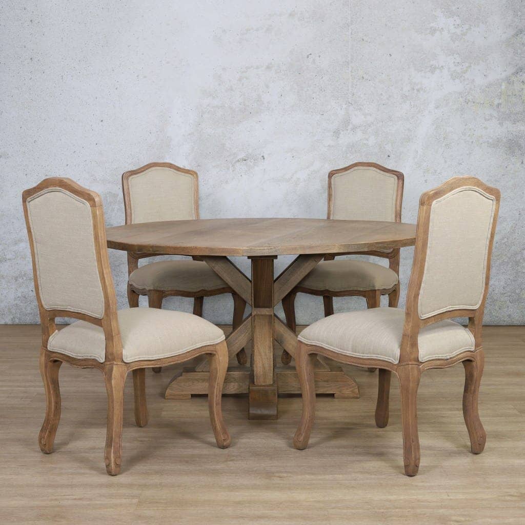 4 seater round dining table made from Oakwood, paired with plush upholstered Duke chairs, creating a warm and inviting dining space.