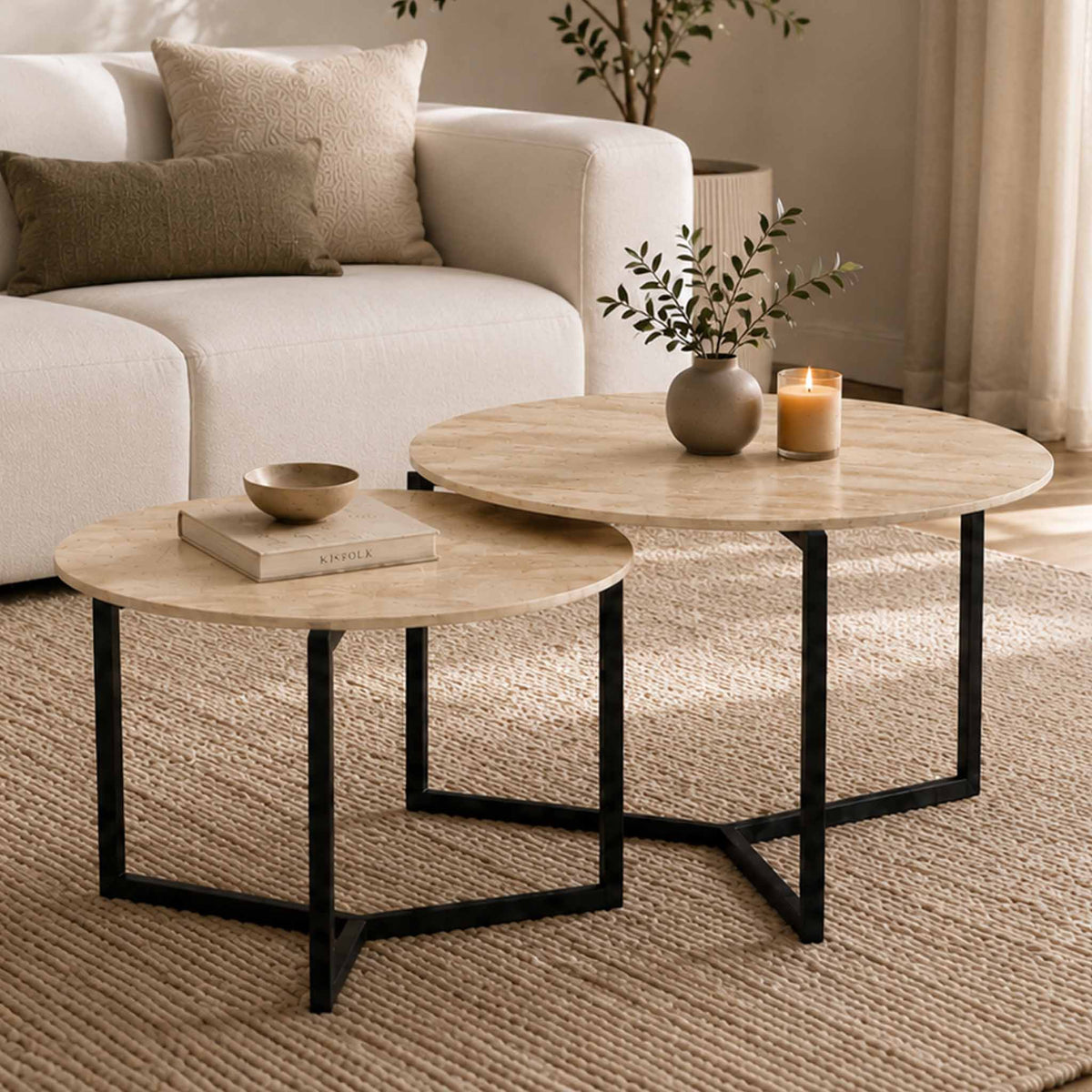 Gallery Everyday Callum Nesting Coffee Tables Set of 2, featuring round light stone-look tops and black metal frames in a modern living room.