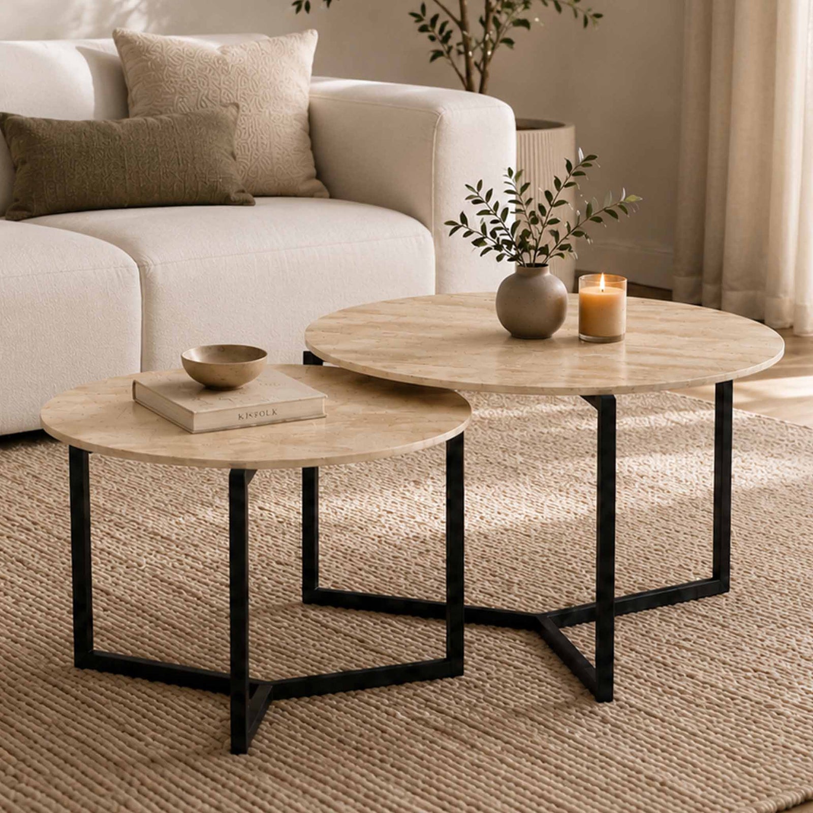Gallery Everyday Callum Nesting Coffee Tables Set of 2, featuring round light stone-look tops and black metal frames in a modern living room.