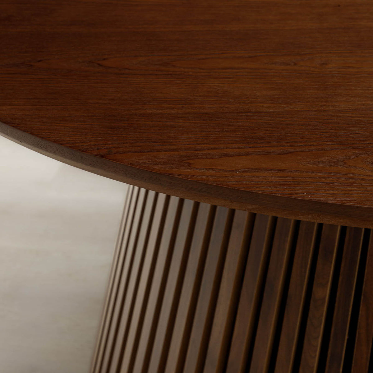 Close-up of Camden dining table's walnut tabletop edge and tambour base. | round dining table, wood dining table, 4 seater dining table