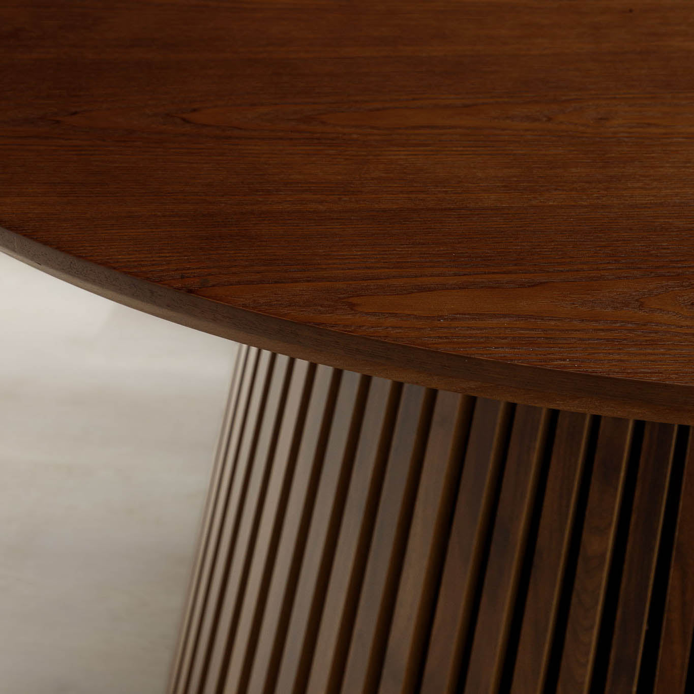 Close-up of Camden dining table's walnut tabletop edge and tambour base. | round dining table, wood dining table, 4 seater dining table