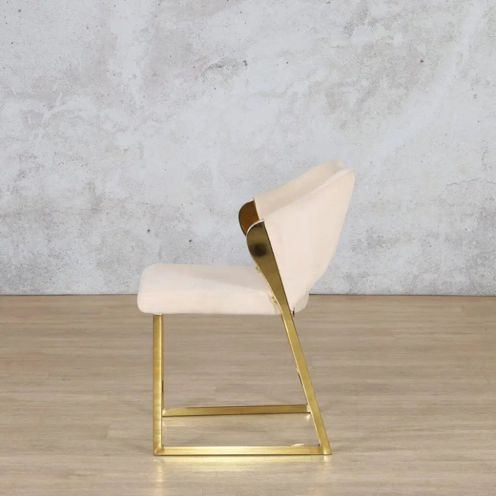 Side view of the Cleopatra gold dining chair highlighting its mirror-finish frame and plush, upholstered backrest.