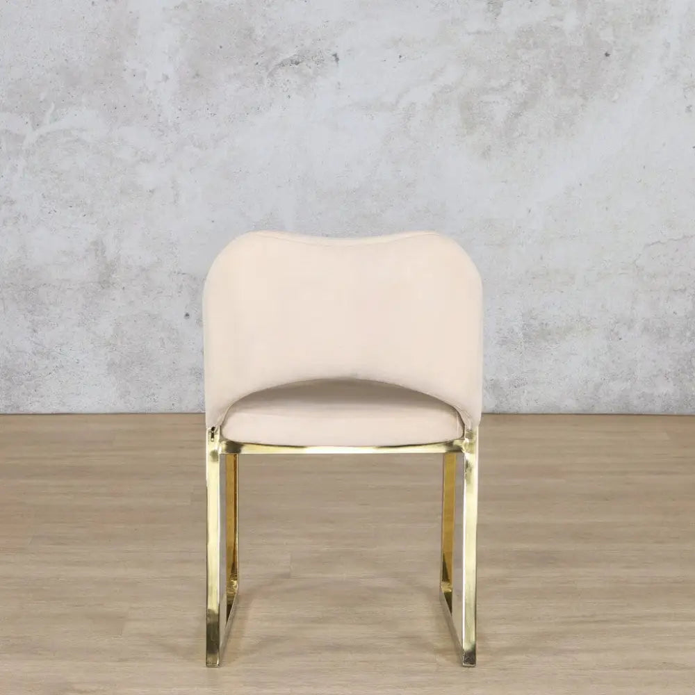 Back view of the Cleopatra gold dining chair highlighting its mirror-finish frame and plush, upholstered backrest.