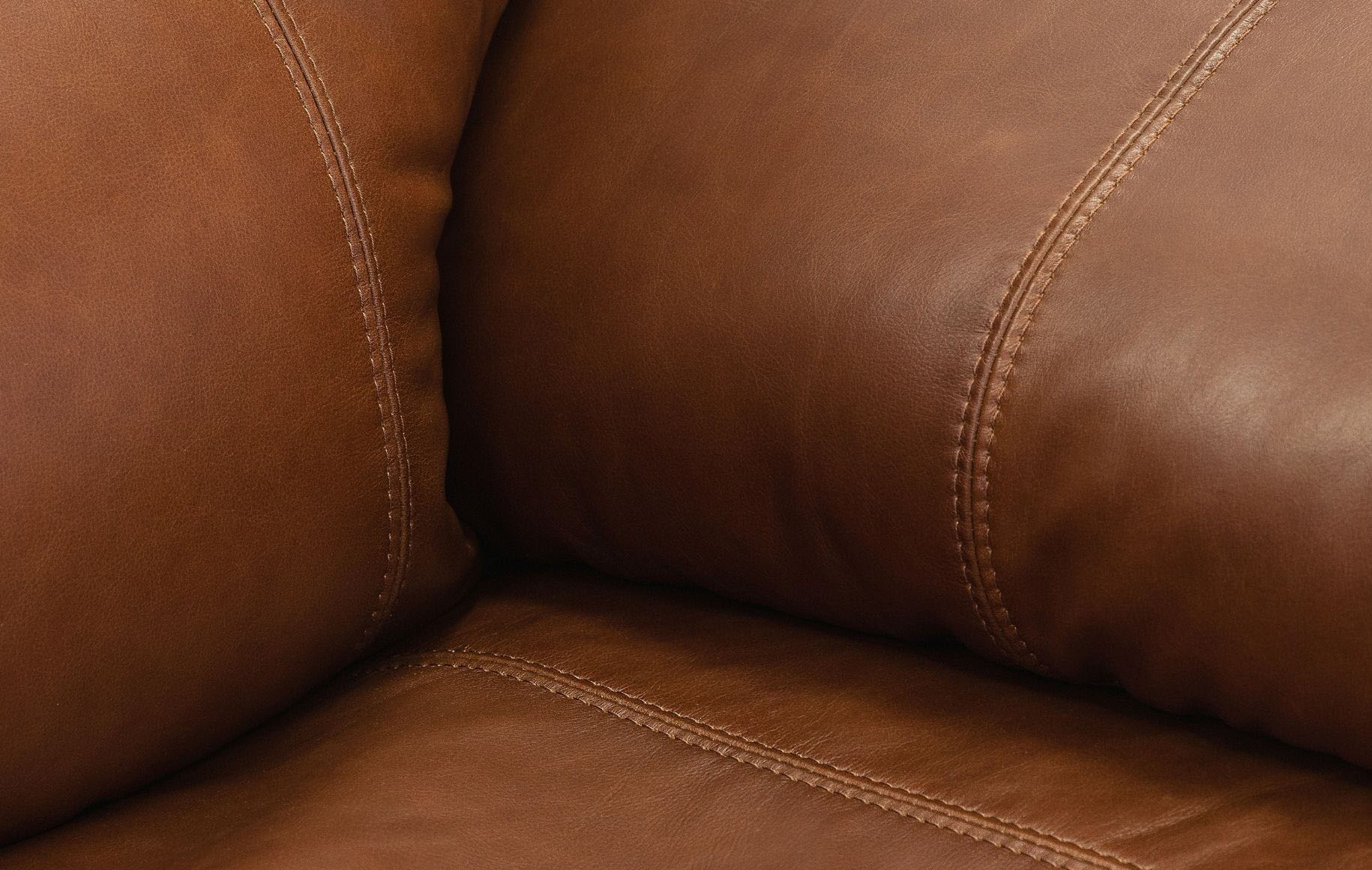 Close-up of detailed stitching on the Geneva leather recliner in Imperial Royal Walnut, highlighting craftsmanship along the seams. | recliner couches, recliner chair