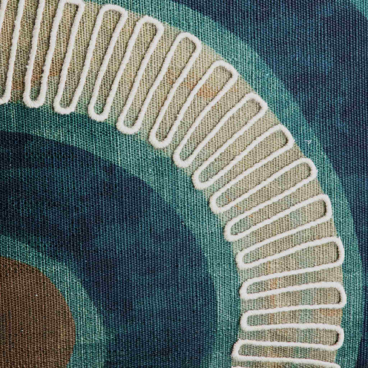 Close-up detail of a Okavango Ocean Cushion, a premium couch cushion showing high-quality woven fabric in teal and navy with raised, white zig-zag embroidery following an arched pattern. | Leather Gallery Scatter Cushions