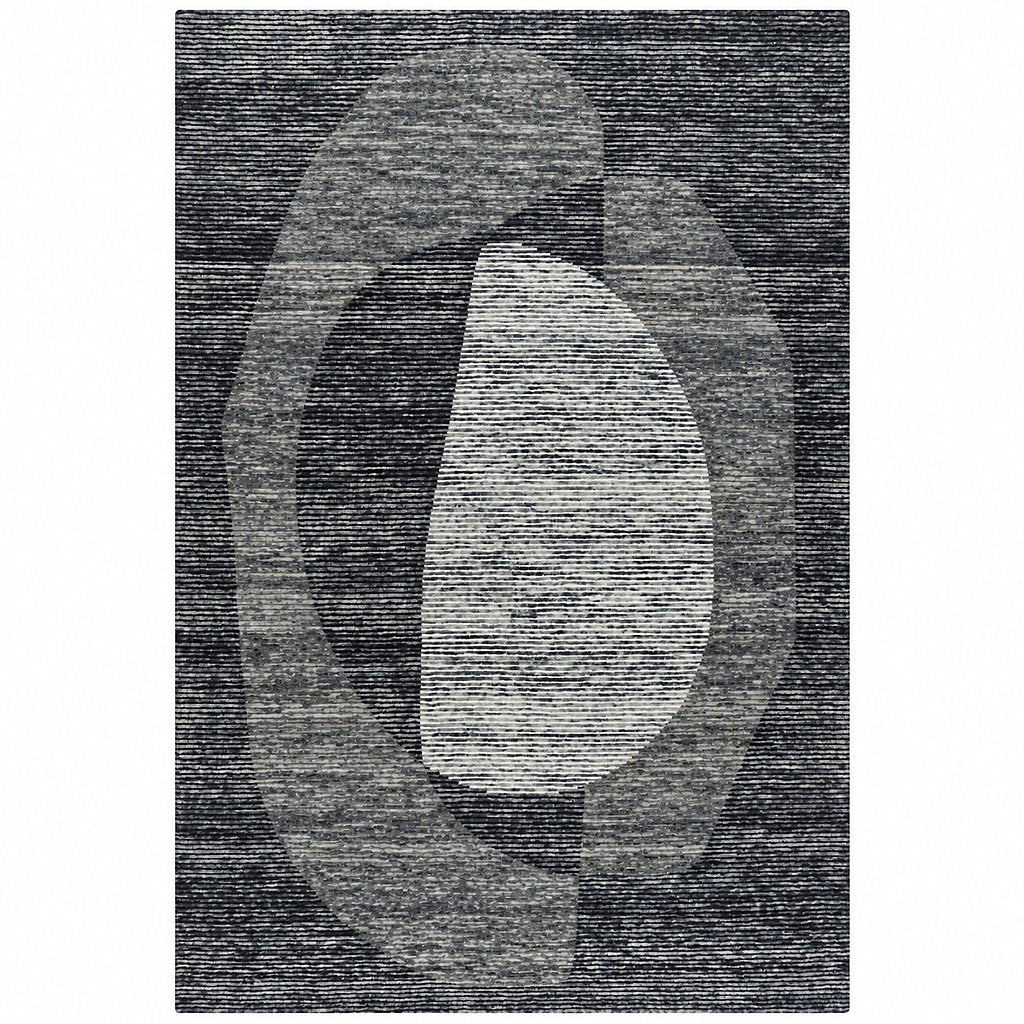 Leather Gallery Dolmen Rug in Ancient Slate, featuring an abstract geometric pattern in charcoal, black, and off-white with a textured woven finish.