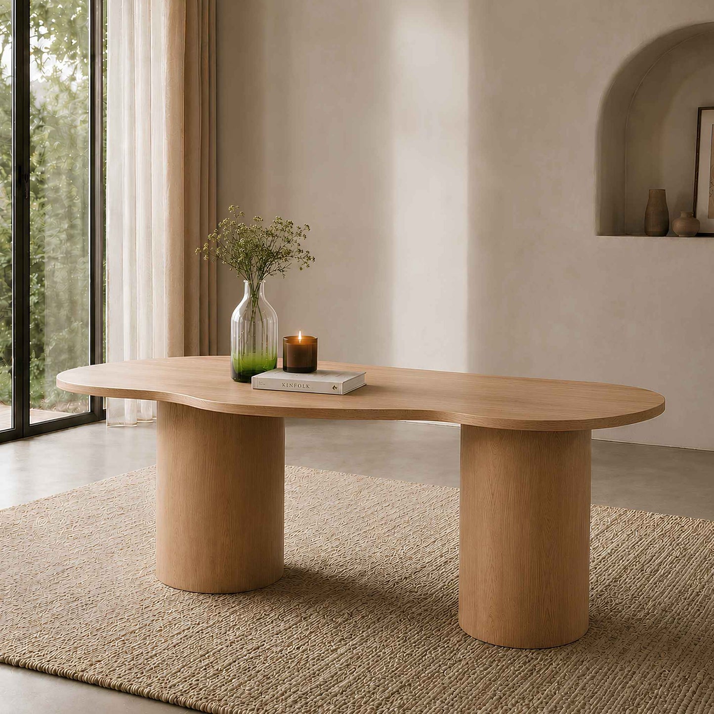 Elodie natural dining table with organic curved top and cylindrical legs styled in a warm, sunlit living space. | 4 seater dining table, wood dining room table, modern dining table, dining room furniture