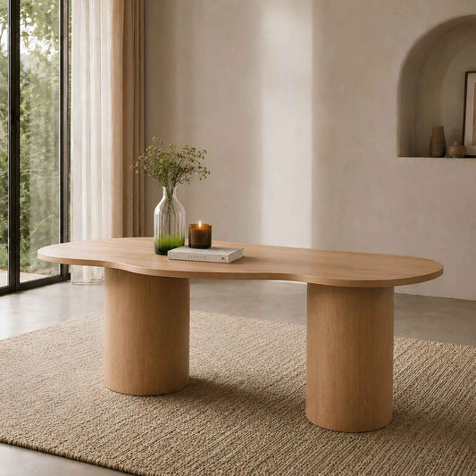 Elodie natural dining table with organic curved top and cylindrical legs styled in a warm, sunlit living space. | 4 seater dining table, wood dining room table, modern dining table, dining room furniture