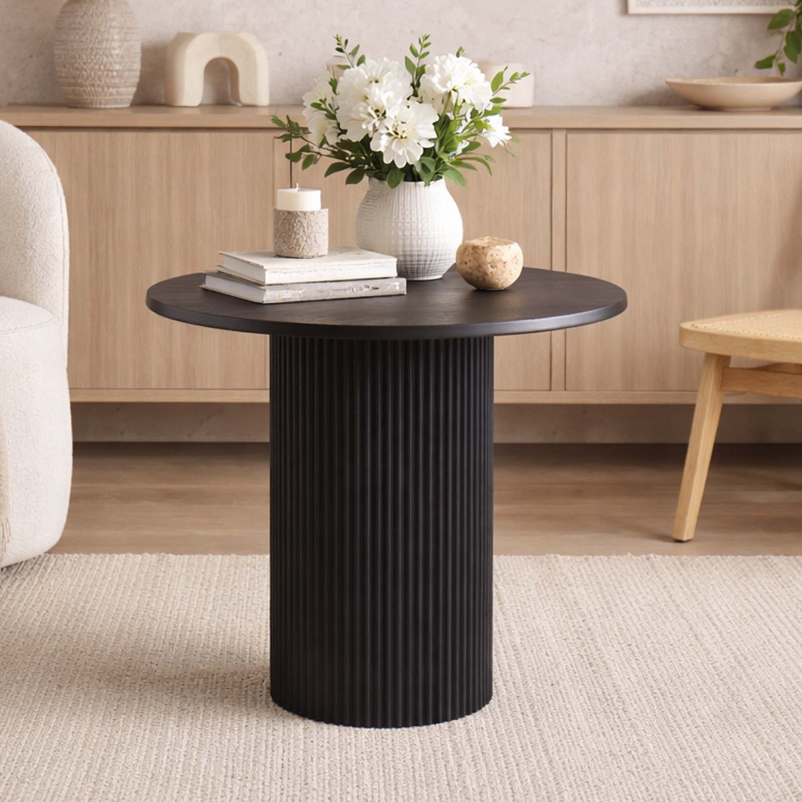 Helmsley Coffee table in a rich black hue, shown as an accent piece in a stylish living room. | Coffee tables, coffee tables for sale, round coffee table, wood coffee table 