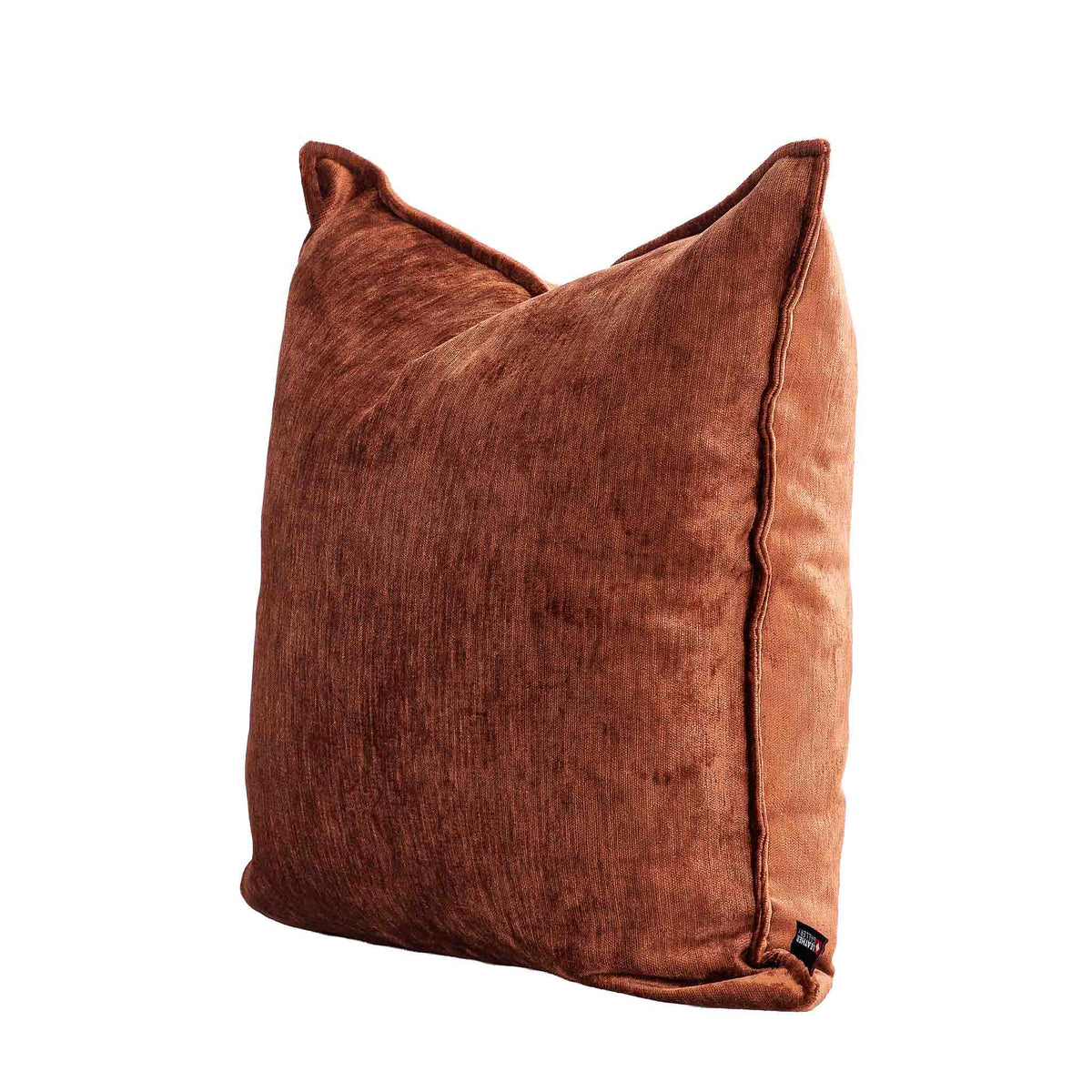 Leather Gallery Vista Plateau Cushion in Burnt Clay, shown at a three-quarter angle with textured rust-brown fabric.