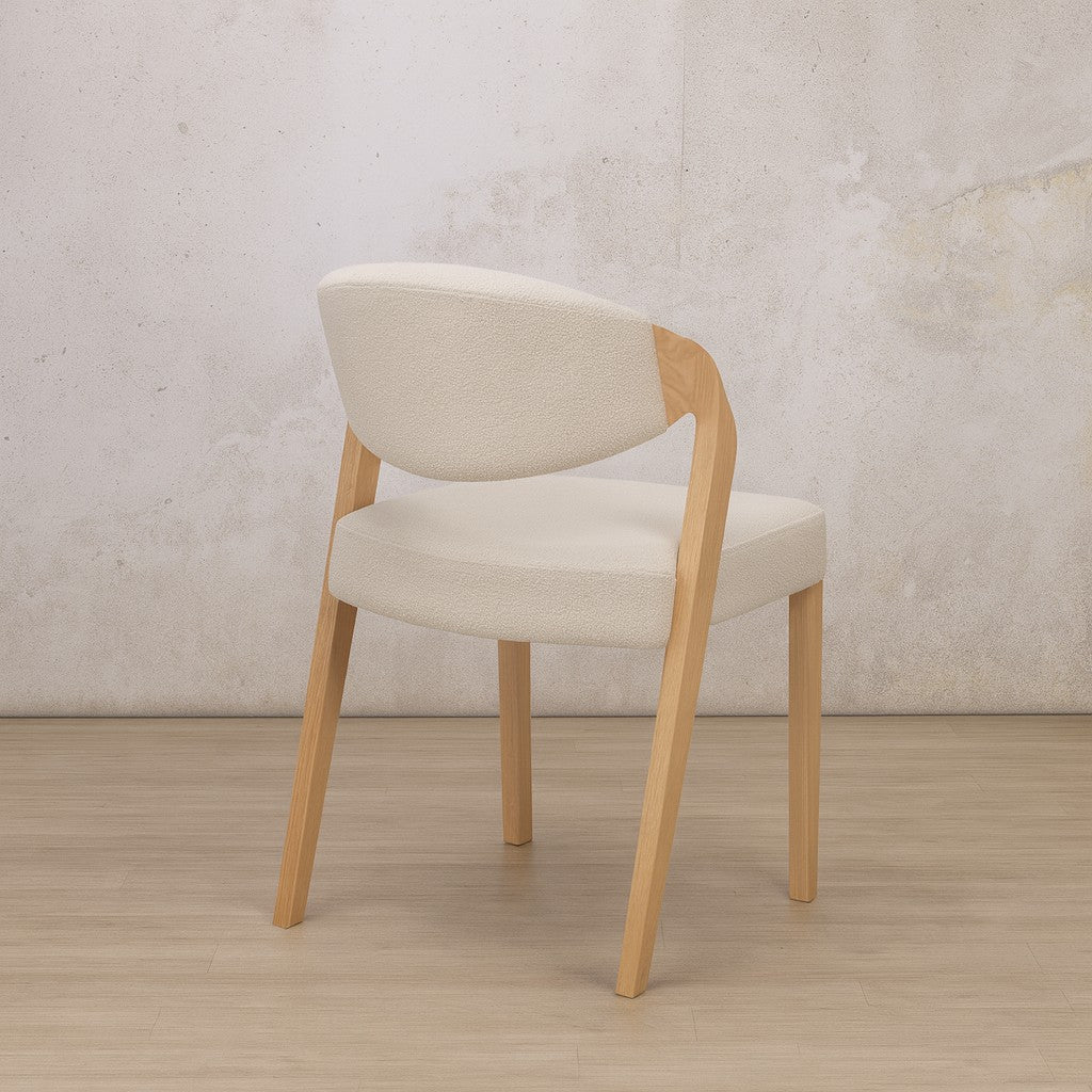 Back view of the natural Keanu Fabric Dining Chair, showing its slightly sloped backrest and legs. | dining chairs, modern dining chairs, dining chairs wood