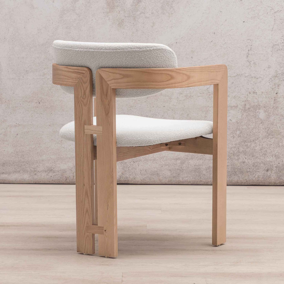 Three-quarter view of Marlon dining chair highlighting geometric wood base and armrests. | wood dining chair, dining chairs south africa, dining chairs