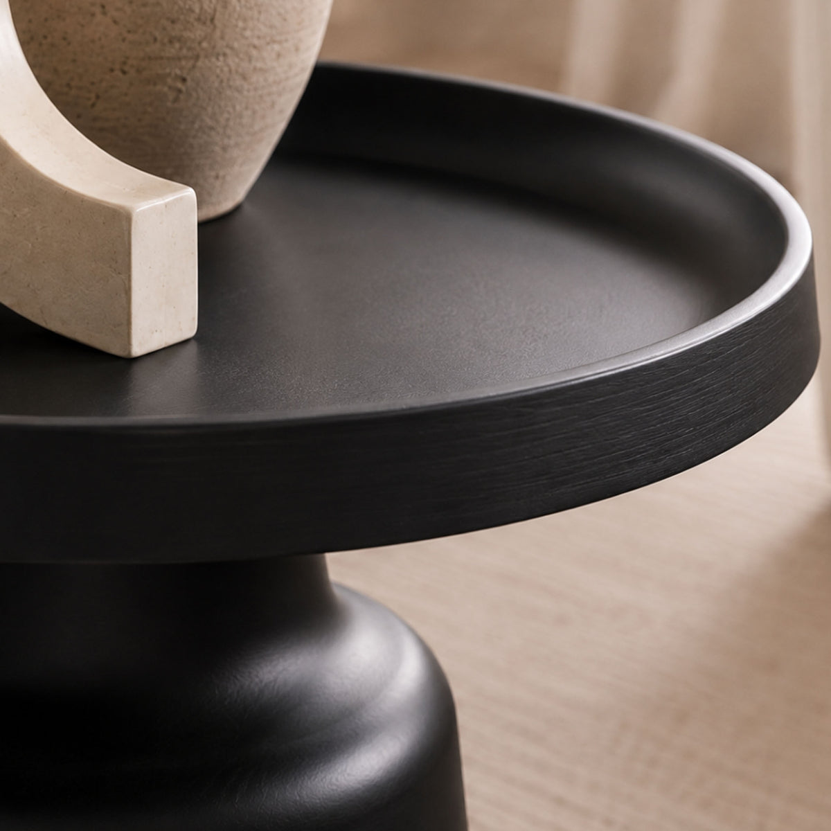 Close-up of the Gallery Everyday Minerva Coffee Table - Black Set of 2, showing the round pedestal design styled with a ceramic vase and sculptural décor.