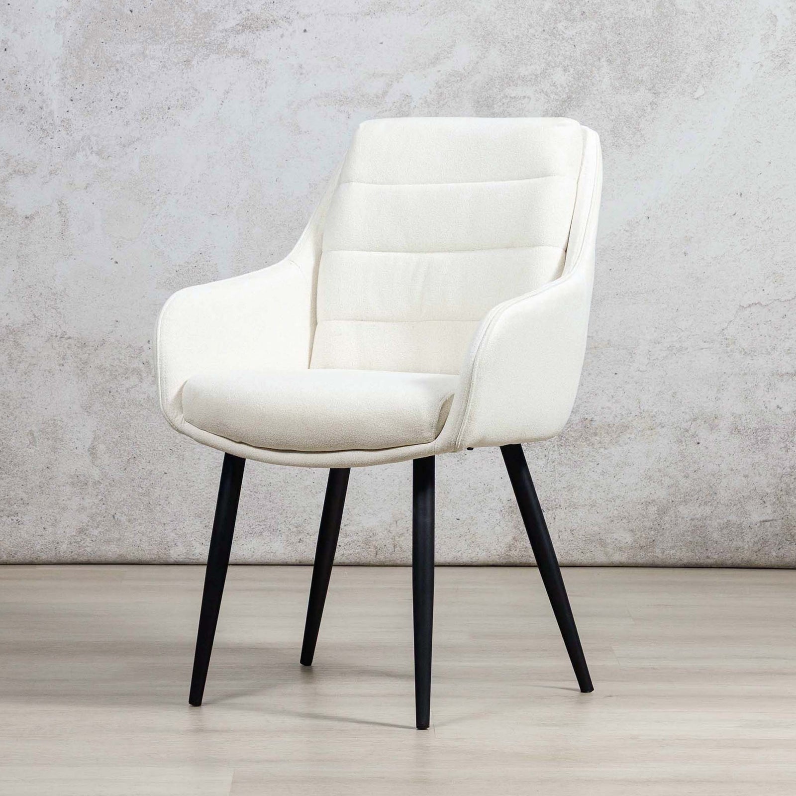 Three-quarter view of Octavia ivory dining chair showing curved armrests and channel stitching. | dining chairs, modern dining chairs, fabric dining chairs 