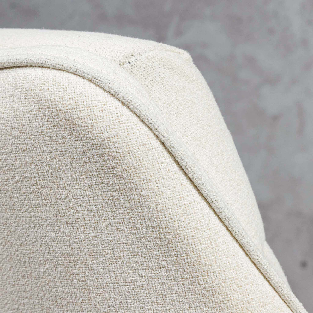 Close-up of Octavia dining chair's curved armrest and linen upholstery, in a soft ivory hue. | dining chairs, fabric dining chair