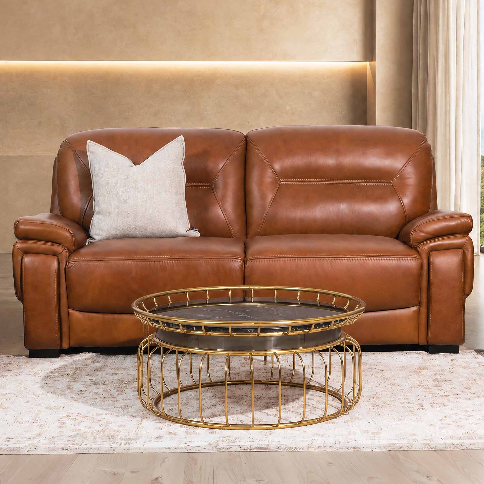 Leather Gallery San Lorenze 2 Seater Leather Couch in Czar Pecan, styled with a neutral cushion and gold coffee table in a modern living room.