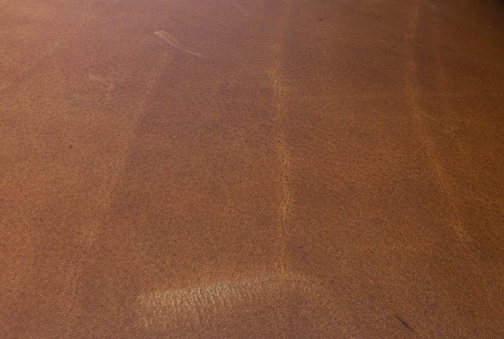 Close-up shot of leather furniture showing distinctive scars and scratch marks for an artisanal look.