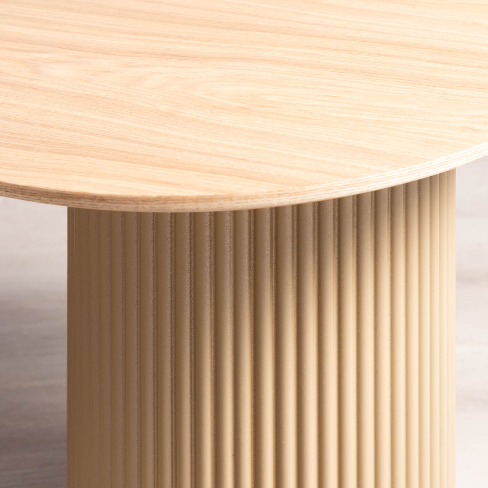 Close-up of Sybil coffee table's fluted pedestal base and tabletop edge. 