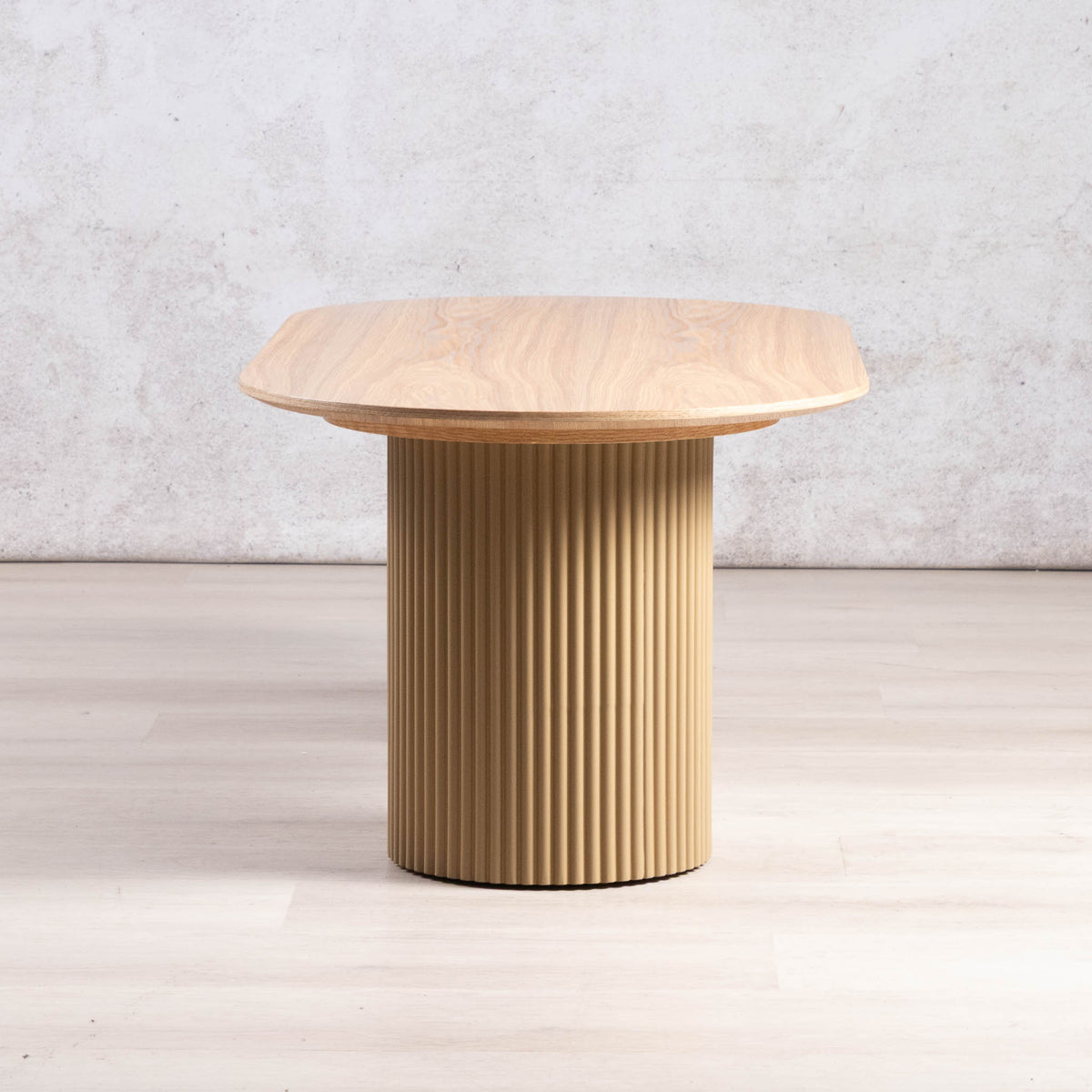 Sybil natural wood coffee table with fluted cylindrical pedestal legs, side view