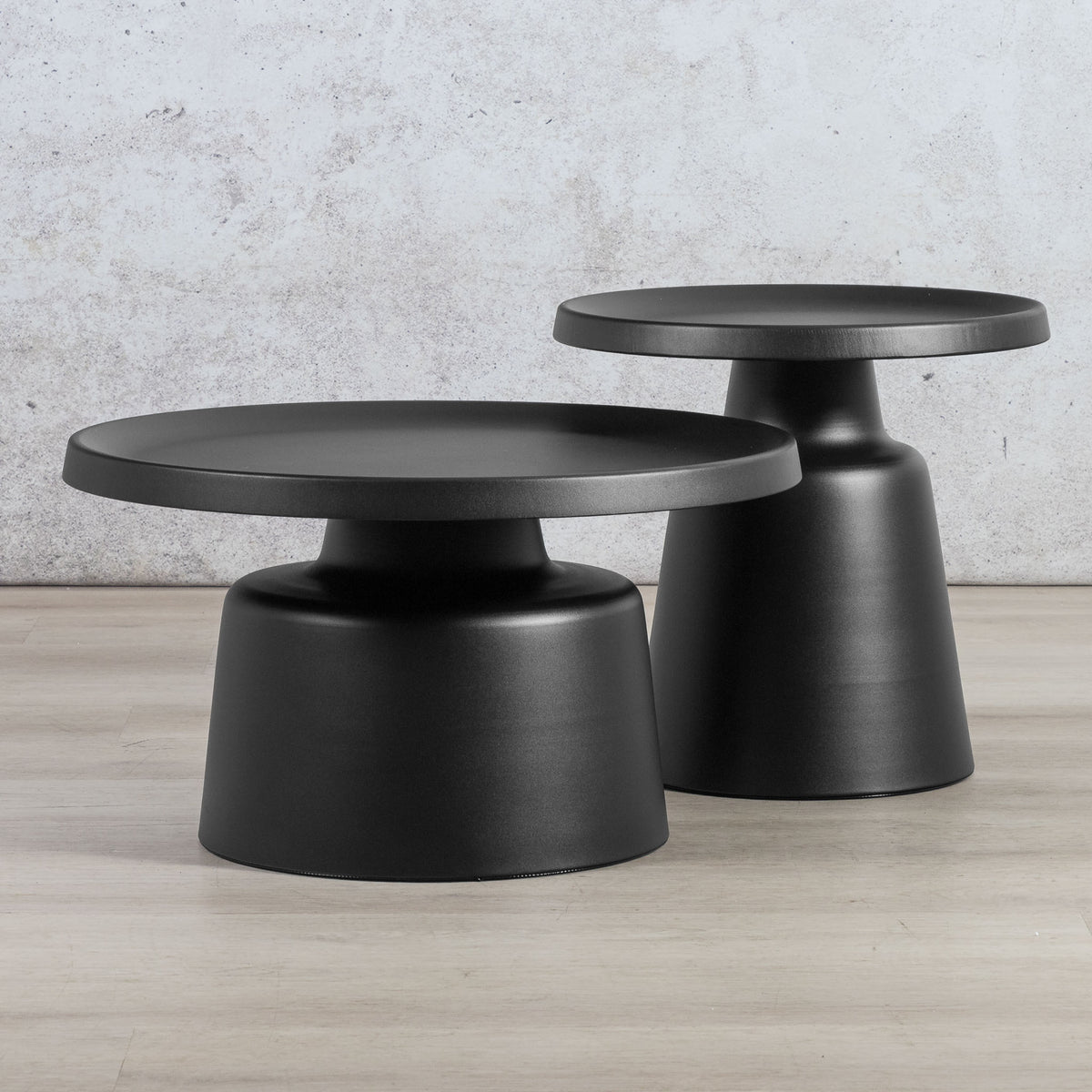 Gallery Everyday Minerva Coffee Table - Black Set of 2, featuring two minimalist black pedestal tables on a wooden floor.