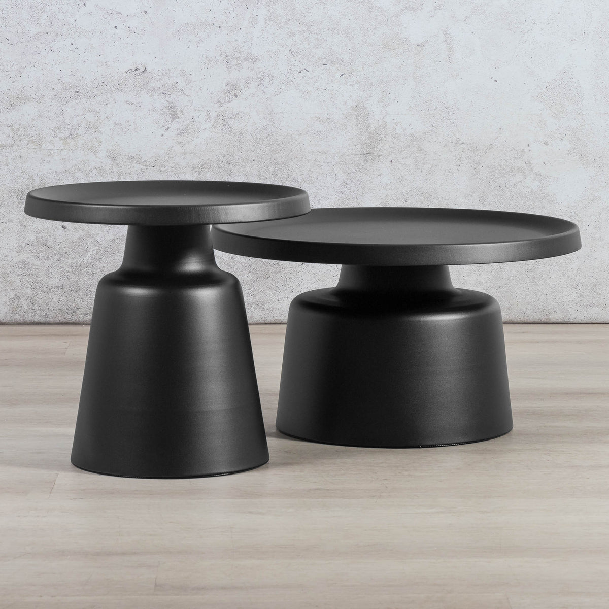 Gallery Everyday Minerva Coffee Table - Black Set of 2, featuring two minimalist black pedestal tables on a wooden floor.