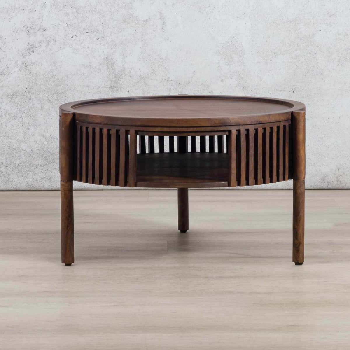 Full view of a round Cassis coffee table with a slatted frame and open shelf, a top choice for those searching for a coffee table for their lounge.