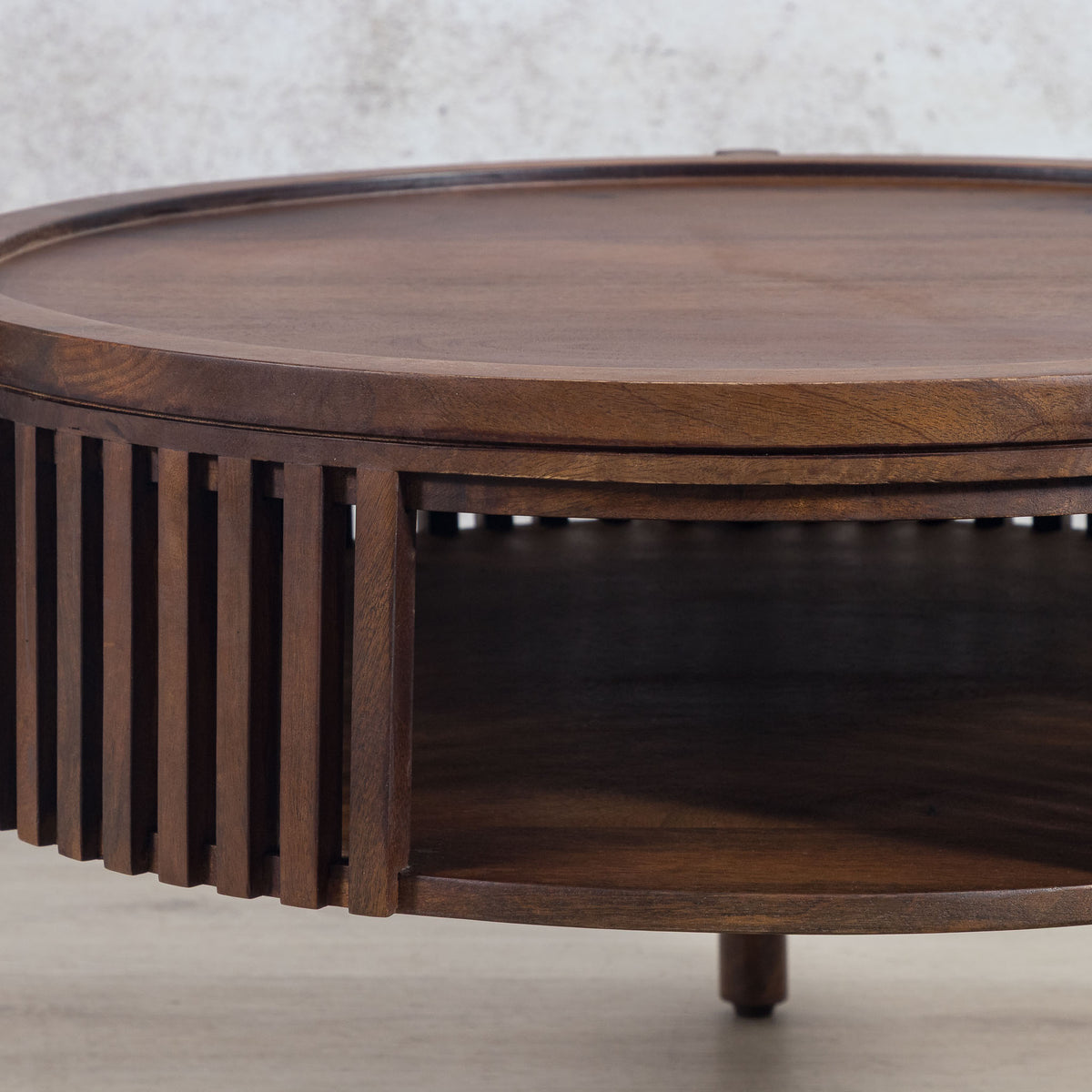 Detailed view of the natural wood grain and slatted base of the Cassis round coffee table, highlighting the craftsmanship and material.
