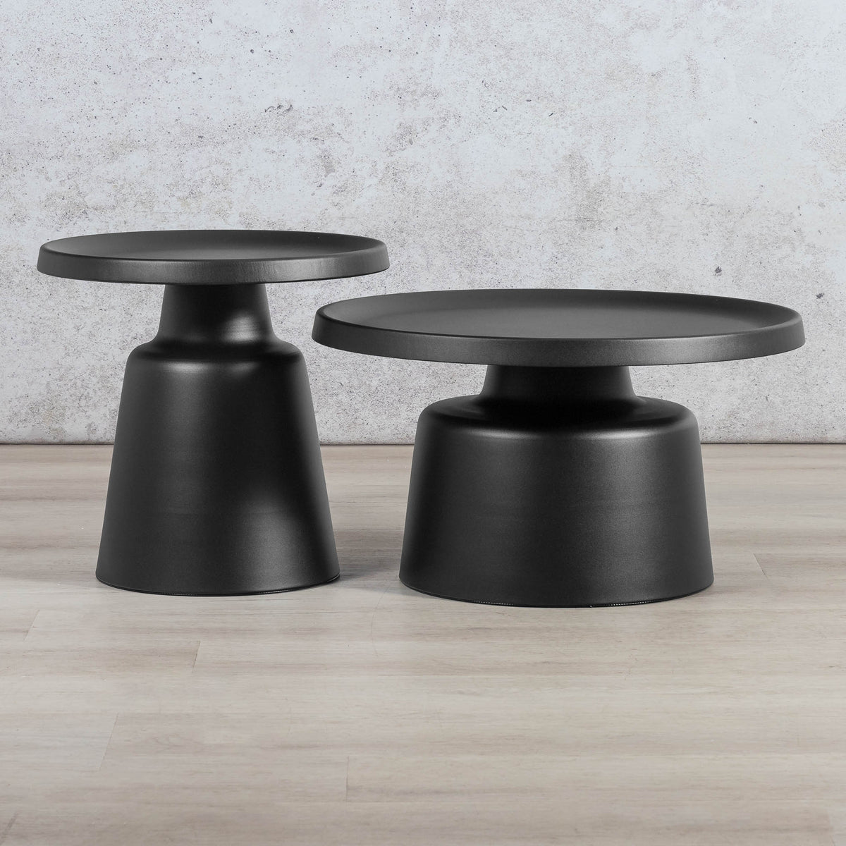 Gallery Everyday Minerva Coffee Table - Black Set of 2, featuring two minimalist black pedestal tables on a wooden floor.