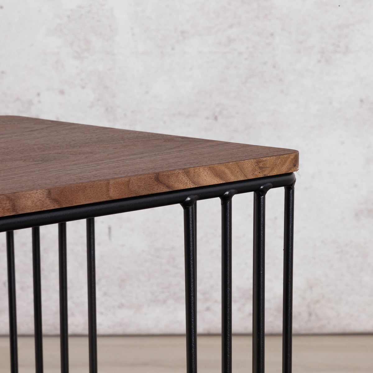 Close-up of the Gallery Everyday Camila Side Table in Walnut, showing the wood-grain tabletop corner and black metal slatted base.