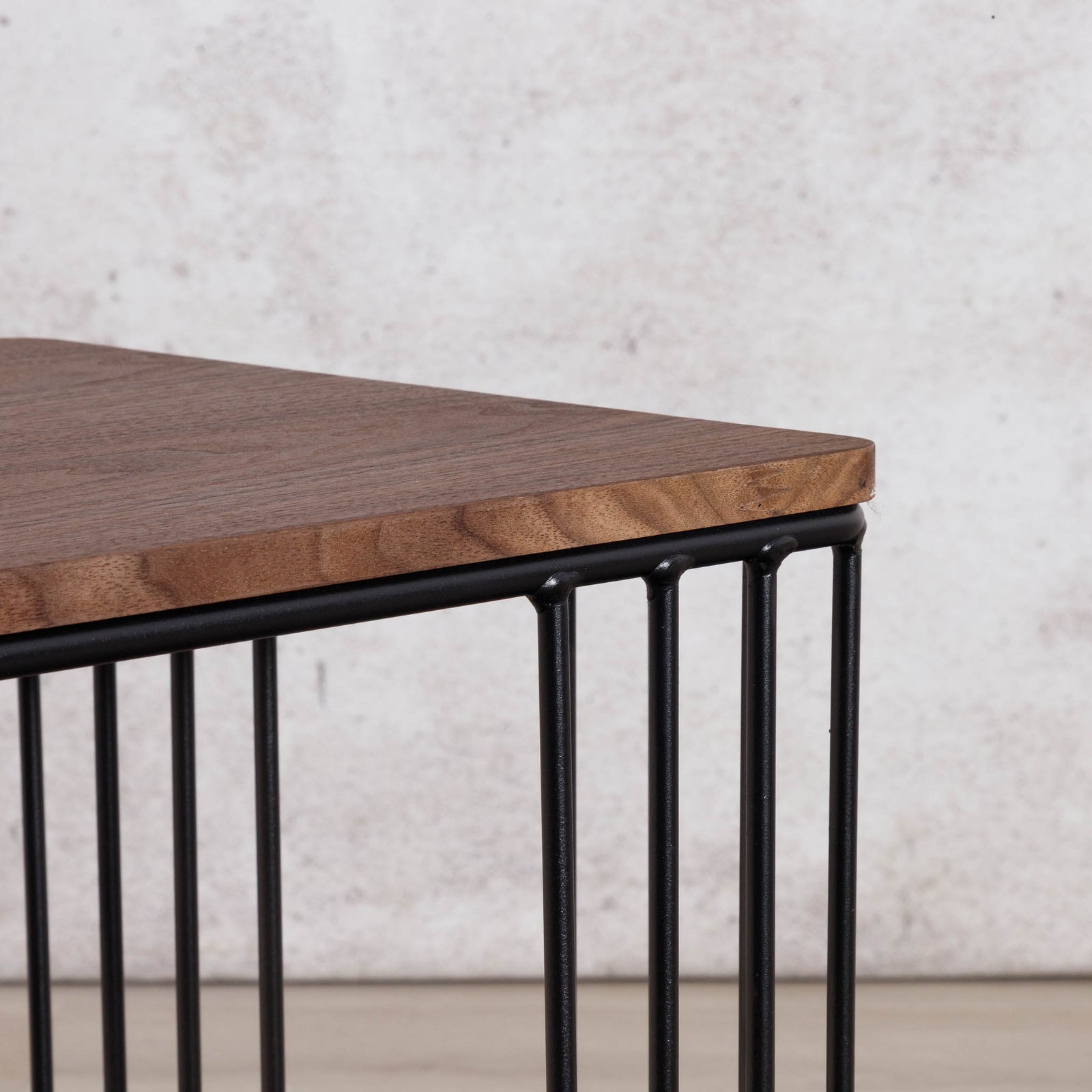 Close-up of the Gallery Everyday Camila Side Table in Walnut, showing the wood-grain tabletop corner and black metal slatted base.