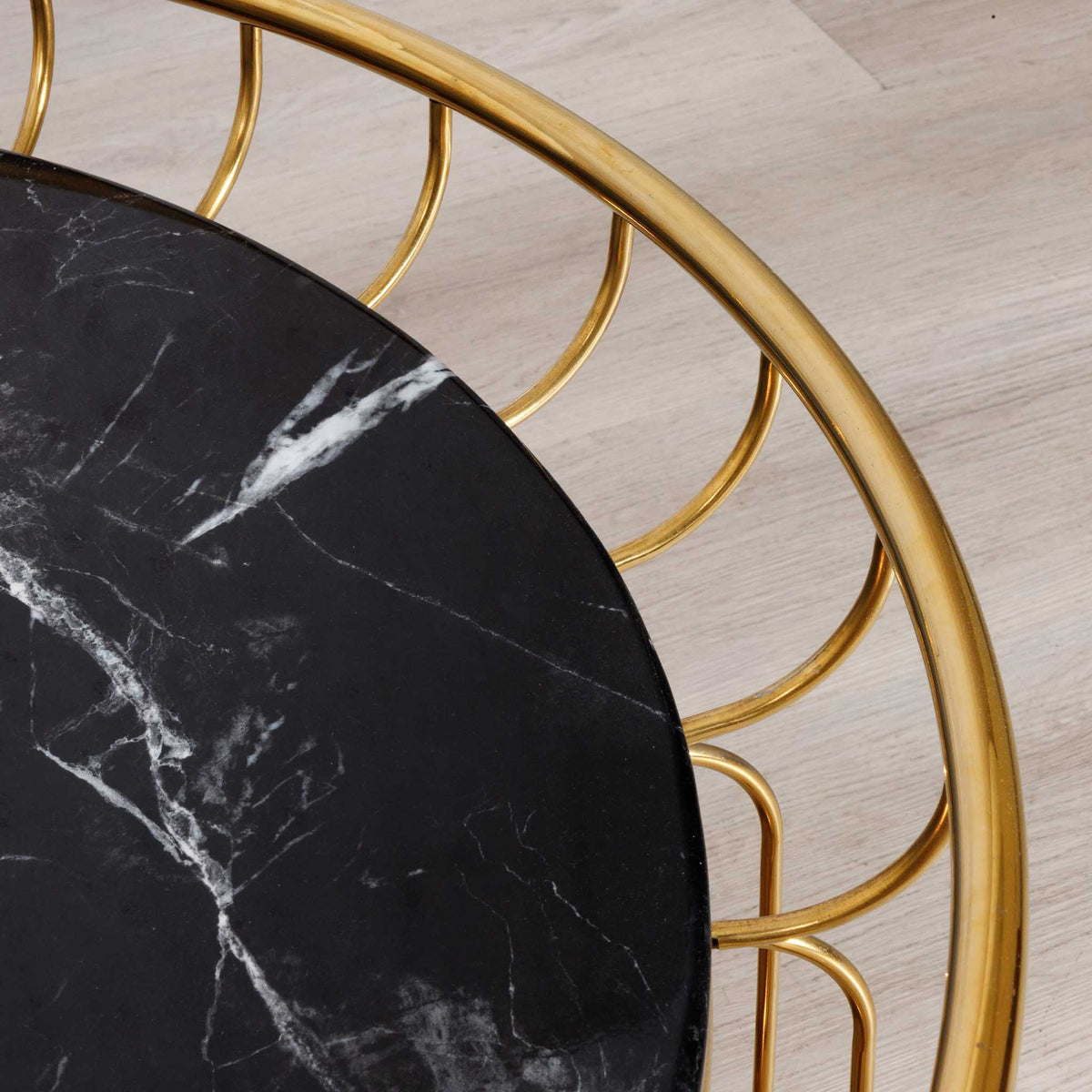 Close-up of the Leather Gallery Eve Coffee Table, showing the black marble top with white veining and scalloped gold metal frame.