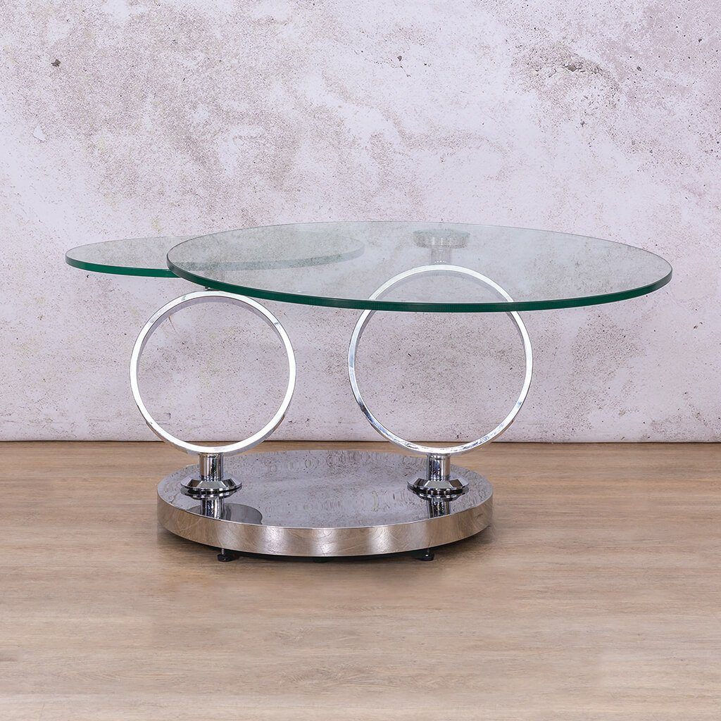 The Futuristic Swivel Coffee Table is a modern statement piece with two stunning finishes: clear glass with a silver stainless-steel base or white marble look with a black base and gold accents. Its pivoting top and dual surfaces provide functionality and elegance, making it a versatile coffee table for any living room.